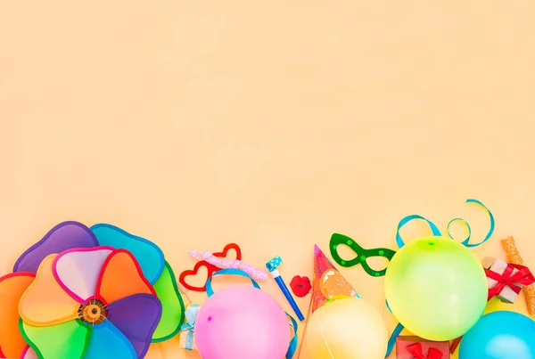 Vista superior brillante partido herramientas y decoración balones, divertidas máscaras de carnaval, oropel festivo sobre fondo de color melocotón. Feliz cumpleaños tarjeta de felicitación. Concepto de diseño. Seleccionar enfoque, lugar para texto . —  Fotos de Stock