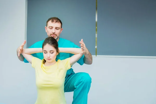 Jovem mulher recebendo massagem do terapeuta. Um quiroprático a esticar a coluna do paciente no consultório médico. Exame físico neurológico. Osteopatia, quiropraxia, fisioterapia . — Fotografia de Stock