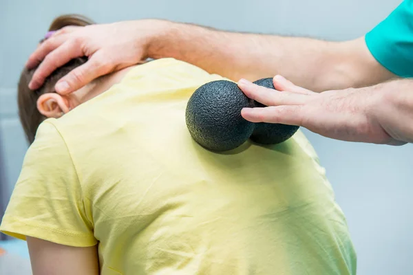 Kvinna på den sjukgymnastik som tar emot bollen massage från terapeuten. En kiropraktor behandlar patientens bröstkorg ryggrad i medicinsk kontor. Neurologi, osteopati, kiropraktik. Selektiv fokus, närbild. — Stockfoto