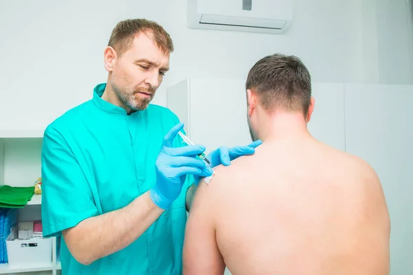 Nörolog doktor bir enjeksiyon tedavisi, abluka erkek hastanın deltoid kas içine yapıyor. Alternatif ağrı tedavi kavramı. Seçici odak, metin için yer. — Stok fotoğraf