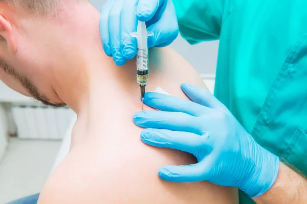 Close up Neurologist doctor makes an injection therapy (blockade) into trapezium muscle of male patient. Alternative pain treatment concept. Selective focus, space for text. — Stock Photo, Image