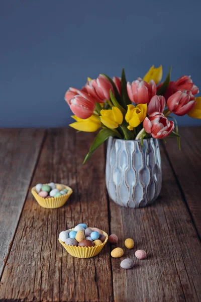 Osterbonbons Überzogen Eier Verschiedenen Pastellfarben Papierkörben Der Nähe Der Vase — Stockfoto