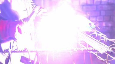 Kaynakçı. İnşaat demiri kaynak. Kıvılcım parlak sprey. Yakın çekim.