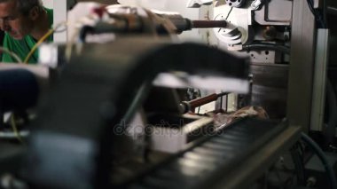 Şirketin üretim Departmanı. Sosis için film üretimi. Dönen elemanların. Yüksek teknoloji ekipman. Üretim ekipmanları yakın çekim öğeleri. Sıcak renk sınıflandırma. Esnek kablo kanalı