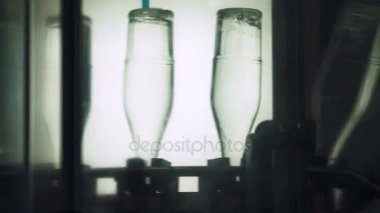 Alkol cam şişelerde tesisinde sızıntısı. Konveyör bant cam şişe ile. Alkollü içeceklerin dökülme alışveriş. Konveyör yakın çekim. Alkollü içki üretim süreci. 4 k res.
