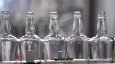 Alkol cam şişelerde tesisinde sızıntısı. Konveyör bant cam şişe ile. Alkollü içeceklerin dökülme alışveriş. Konveyör yakın çekim. Alkollü içki üretim süreci. 4 k res.