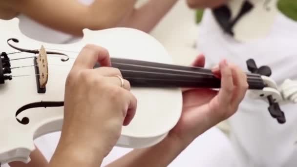 Ragazza in vestito bianco gioca il violino bianco. Primo piano del violino. — Video Stock