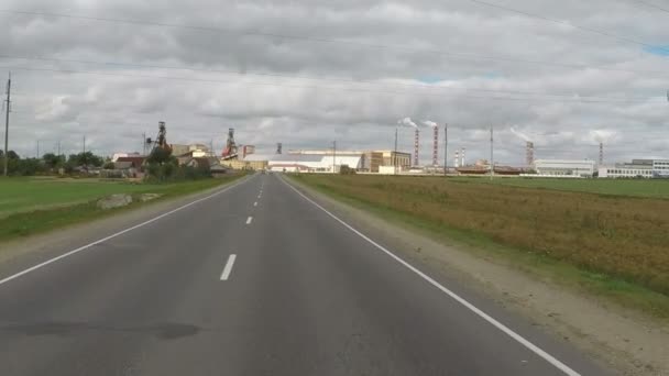 Estrada para a cidade industrial com chaminé fumaça — Vídeo de Stock