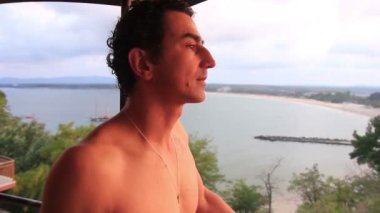 Mutlu rahatlatıcı adam balkonda etrafa yaz tatil keyfini çıkarın