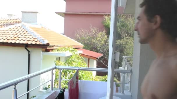 Glücklich entspannter Mann auf Balkon genießt seinen Sommerurlaub — Stockvideo