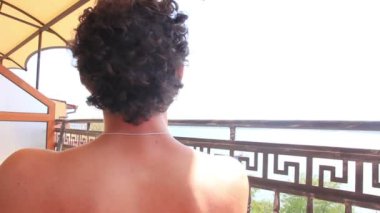 Mutlu rahatlatıcı adam balkonda etrafa yaz tatil keyfini çıkarın
