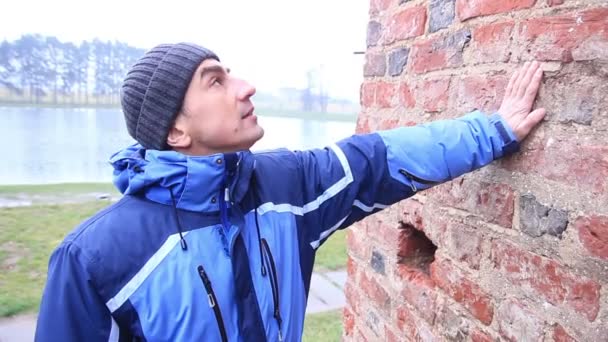 Man toeristische geschiedenis minnaar kijken naar oude muur — Stockvideo