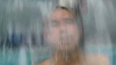 Adam havuz şelale altında rahatlatıcı