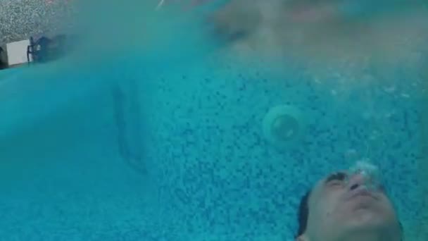 Чоловік плаває під водою в басейні — стокове відео