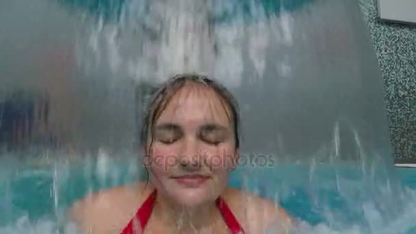 Mujer en la piscina Relajándose bajo la cascada — Vídeos de Stock