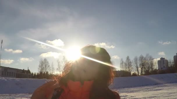 Mujer sacudiendo el cabello frente al sol — Vídeos de Stock