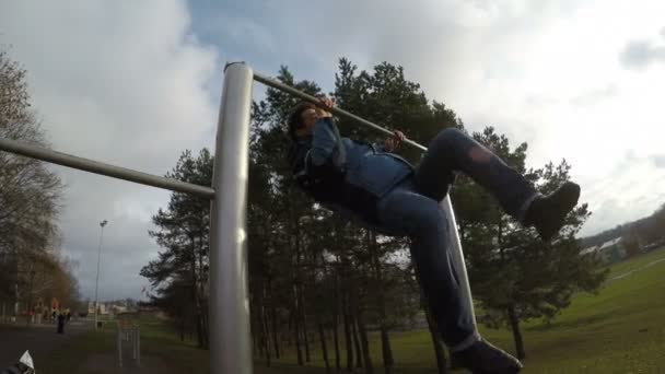 Homem esportivo fazendo truque na barra horizontal — Vídeo de Stock