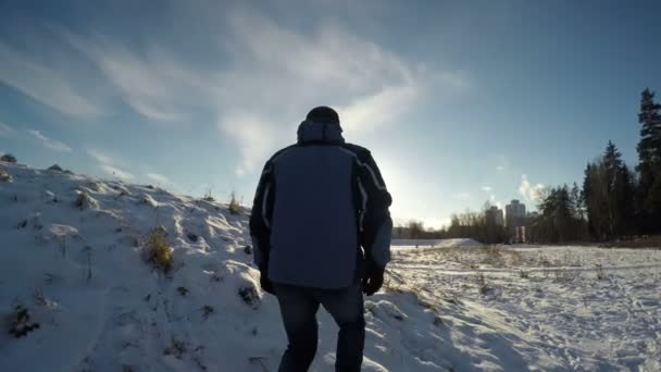 Kış güneşte doğru yürüyen adam — Stok video