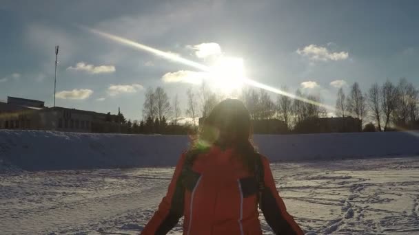 Winterporträt einer Frau, die in der Sonne in die Kamera blickt — Stockvideo