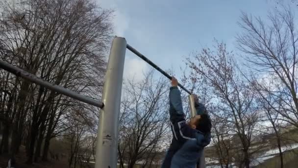 Спортивный человек, делающий трюк на горизонтальной панели — стоковое видео