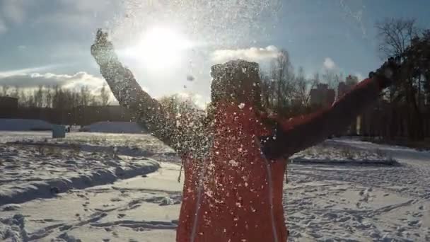 太陽の反対側の雪を投げる女性 — ストック動画