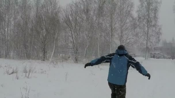 Hombre feliz saltando de alegría en invierno nevada — Vídeos de Stock