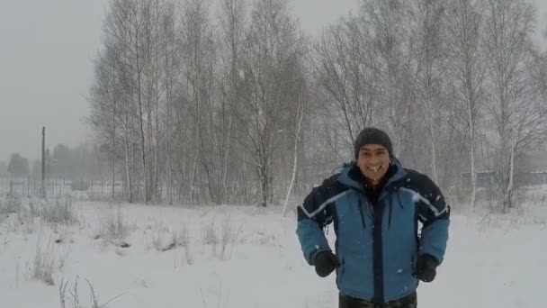 Mannen hoppar av glädje i vinter snöfall — Stockvideo