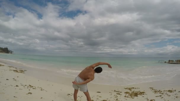 Sportiga mannen gör övning på stranden — Stockvideo