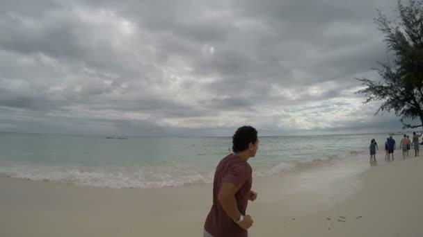 Hombre deportivo corriendo en la playa — Vídeo de stock