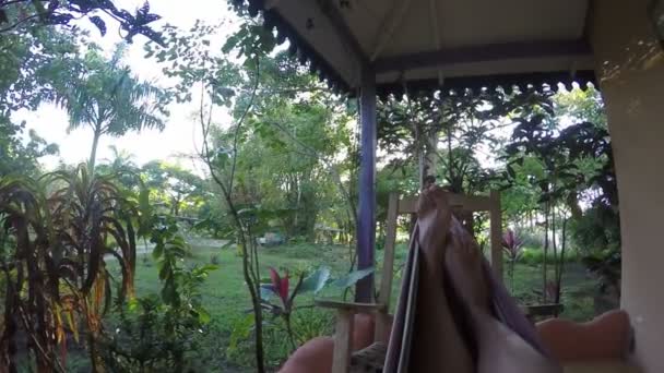 Femme Relaxant dans l'hamac dans le jardin vert 