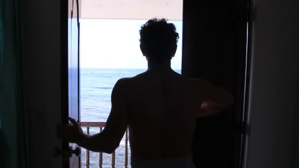 Homem saindo para a varanda com vista mar Desfrute — Vídeo de Stock