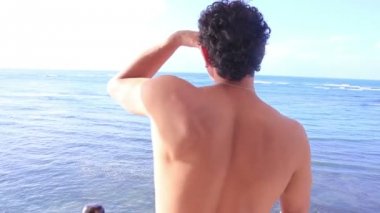 Adam ayakta balkon ve okyanus içine arıyorum