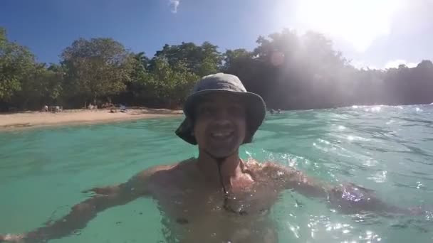 Gelukkig glimlachende Man in Water met leuk strand — Stockvideo