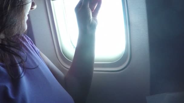 Passagierin öffnet Flugzeugfenster — Stockvideo