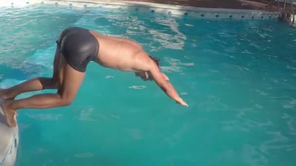 Hombre saltando al agua en la piscina — Vídeo de stock