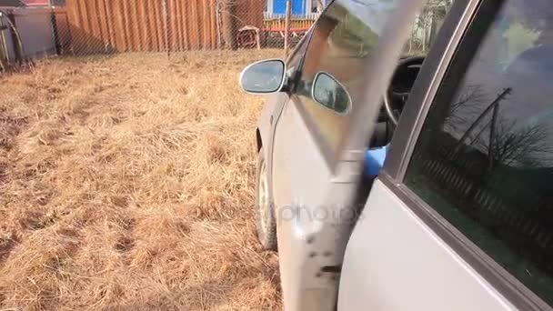 Mann öffnet Autotür und steigt aus — Stockvideo