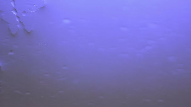 Фиолетовый фон Вода течет по стеклу — стоковое видео