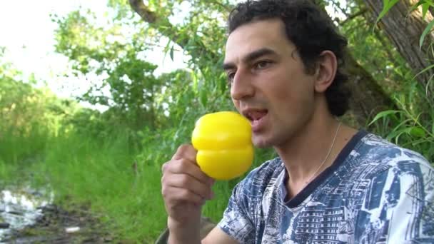 Mann isst gelbe Paprika im Freien vegane Mahlzeit