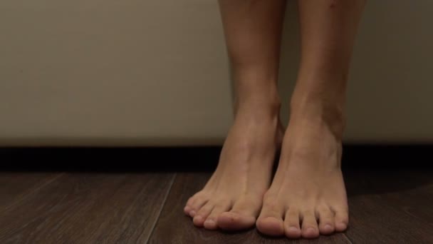 Ноги женщины ложатся в постель вечером — стоковое видео