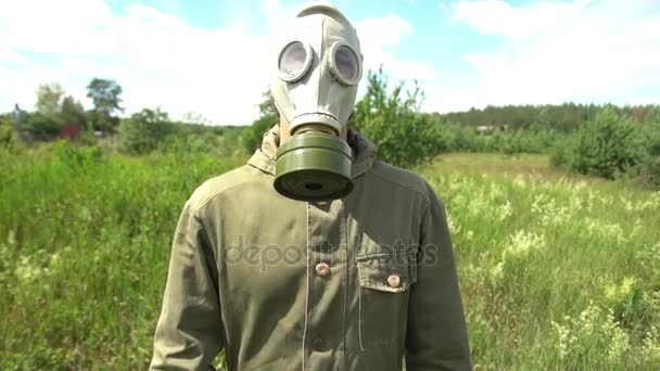 Mannen i gasmask sniffar blommor — Stockvideo