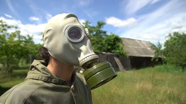 남자 가스 마스크 이륙 및 녹색 풀밭에 호흡 — 비디오