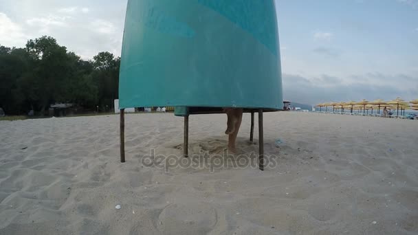 Mujer posponiendo bikini en la cabaña cambiante en la playa — Vídeos de Stock