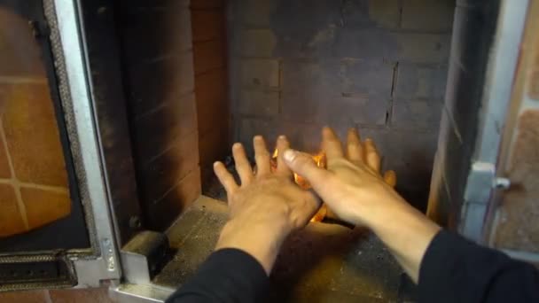 Hombre relajarse junto al fuego caliente y el calentamiento de sus manos, agradable chimenea cómoda en una casa fuera de la ciudad — Vídeo de stock