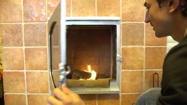 Hombre relajarse junto al fuego caliente y el calentamiento de sus manos, abrir agradable chimenea en una casa fuera de la ciudad — Vídeo de stock