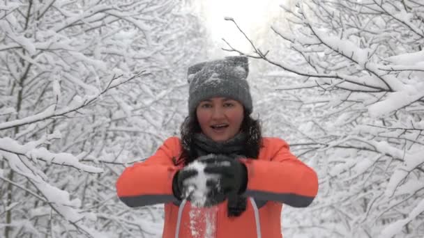 Счастливых женщин перед камерой. снег падает в замедленной съемке 1080 HD. молодая женщина наслаждается зимним днем на открытом воздухе — стоковое видео
