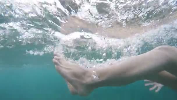 Bela fêmea pés caindo debaixo d 'água. câmera lenta com bolhas, feriados diversão de verão — Vídeo de Stock