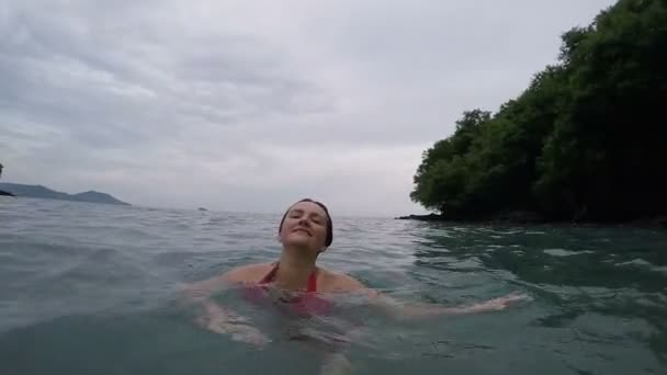 Glücklich aufgeregte Frau in roten Bilini, die im Meerwasser tanzt, Superzeitlupe, Sommerspaß, Ferienkonzept — Stockvideo