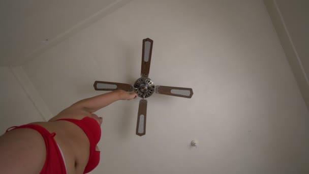 Donna in bikini rosso accendere ventilatore sul soffitto salvarsi dal calore — Video Stock