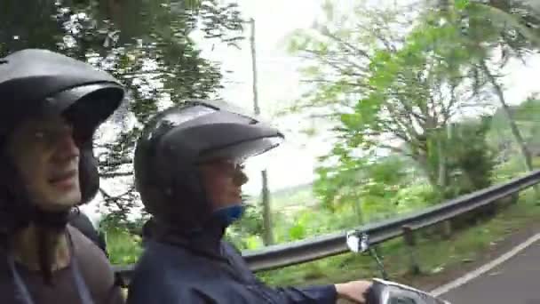 Divertida pareja viajando en moto por la naturaleza verde asiática con jugle road, transporte en asia, tráfico del lado izquierdo, vacaciones felices, turismo, concepto de viaje, selfie, diversión — Vídeo de stock