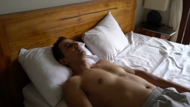 Young happy man waking up in the morning in his hotel room stand up on his bed and looking to window, travel holidays concept, inspirational positive energy — Stock Video